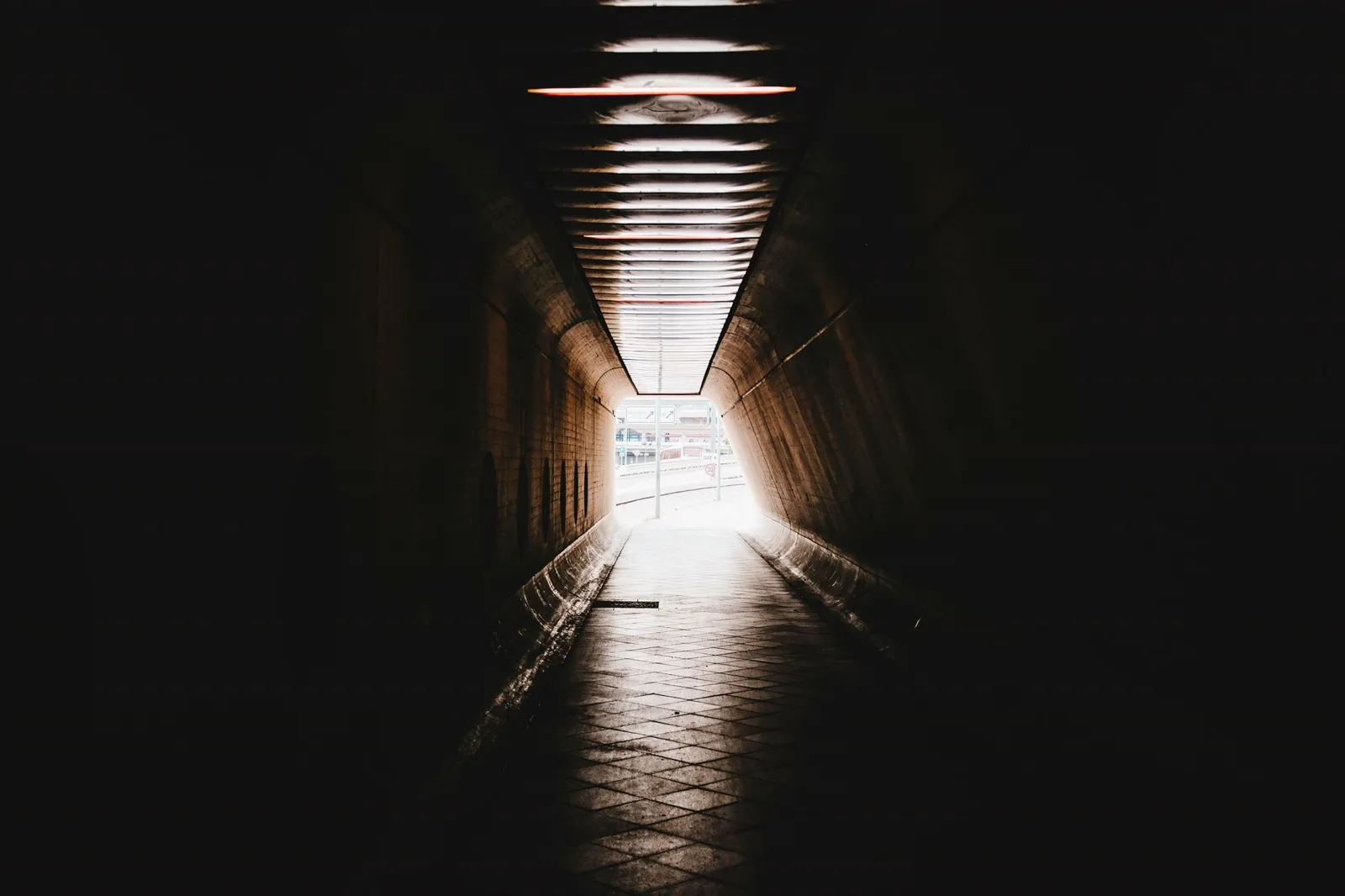 Ciemny tunel ze światłem na końcu — droga na murawę